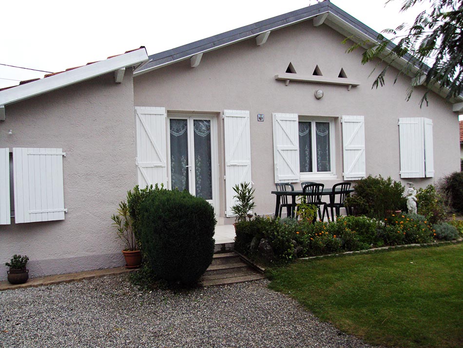 Façade de maison rénovée avec volets blancs par Artisans Façades